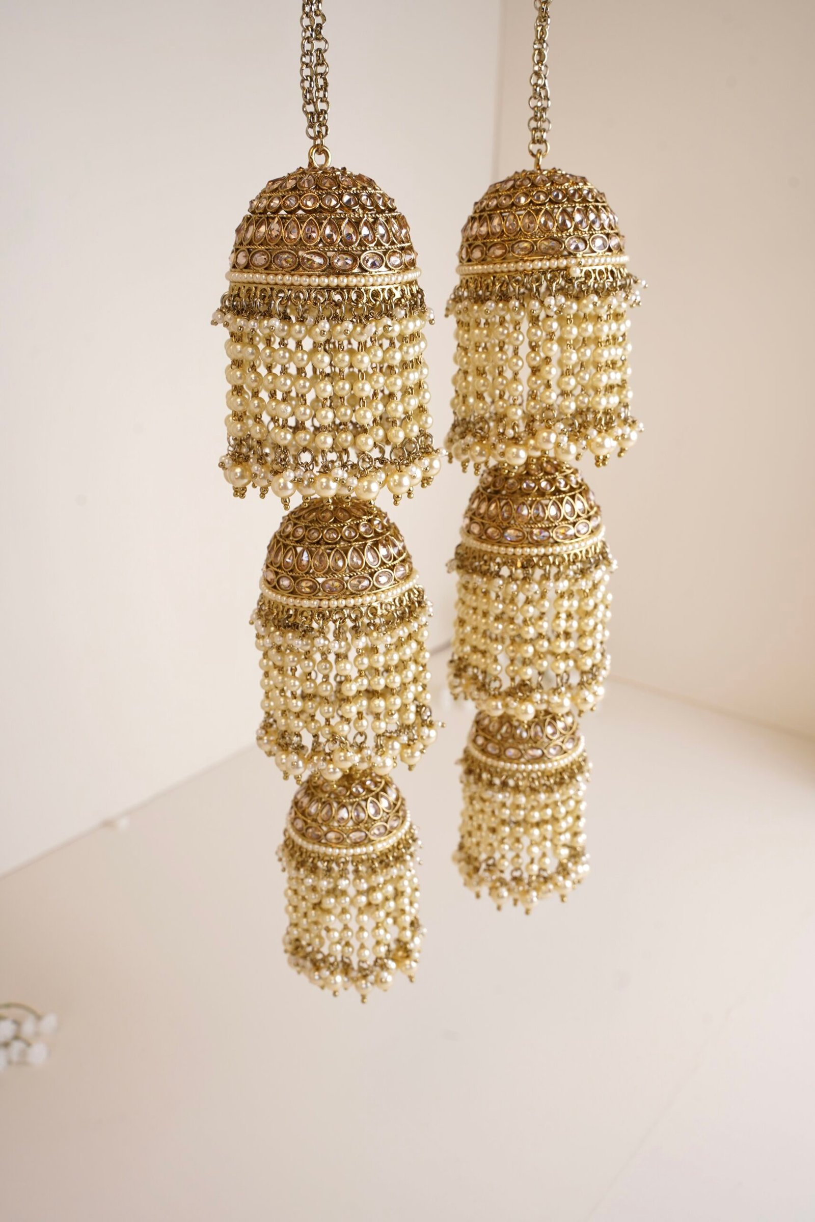 Contemporary bridal wrist jewelry with triple jhumki design