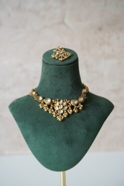 Small delicate floral kundan gold necklace set with jhumka earrings and matching tikka in traditional Indian design