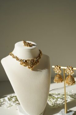 Small delicate floral kundan gold necklace set with jhumka earrings and matching tikka in traditional Indian design
