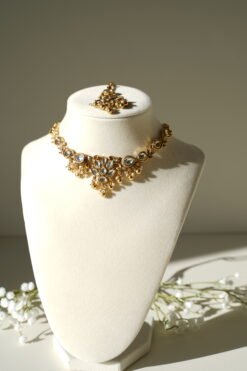 Small delicate floral kundan gold necklace set with jhumka earrings and matching tikka in traditional Indian design