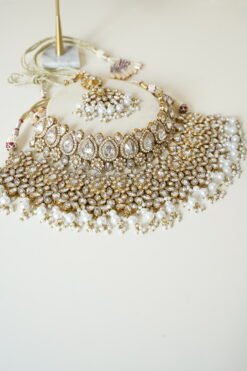Two-layer Indian Pakistani bridal necklace set with clear stones and pearls featuring matching earrings and tikka, adjustable drawstring design for versatile styling