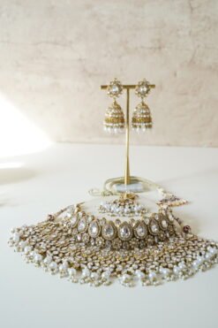 Two-layer Indian Pakistani bridal necklace set with clear stones and pearls featuring matching earrings and tikka, adjustable drawstring design for versatile styling
