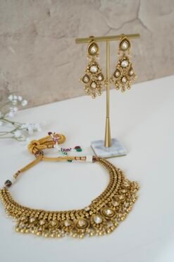 Kundan gold tone necklace set with matching earrings featuring tiny pearl drops and a royal traditional design