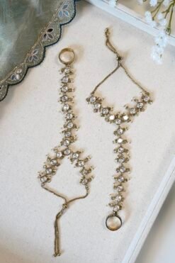 Indian haathphool hand harness with continuous kundan detailing extending from the wrist to the connected ring