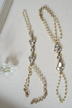 Delicate haathphool hand harness featuring kundan stones and tiny pearl detailing with fine chains
