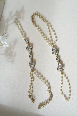 Delicate haathphool hand harness featuring kundan stones and tiny pearl detailing with fine chains