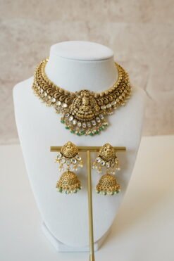 Temple style Kundan necklace set with green stones and matching earrings in gold finish