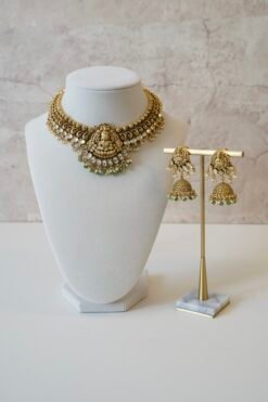 Temple style Kundan necklace set with green stones and matching earrings in gold finish