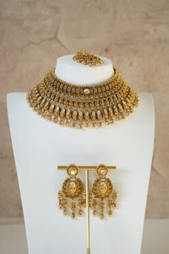 raditional gold finish kundan necklace set with matching earrings and maang tikka, featuring intricate detailing and a bold statement design