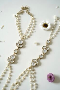 Delicate haathphool hand harness featuring kundan stones and tiny pearl detailing with fine chains