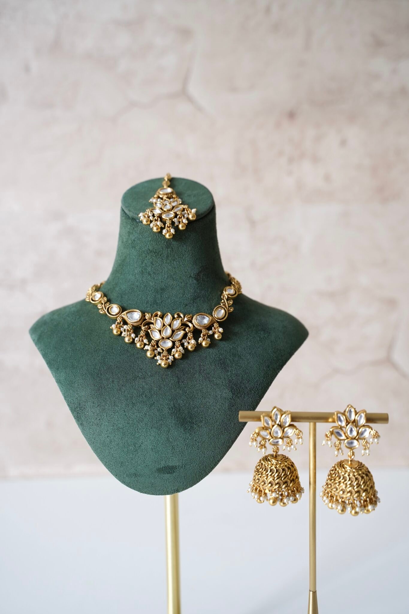 Small delicate floral kundan gold necklace set with jhumka earrings and matching tikka in traditional Indian design 