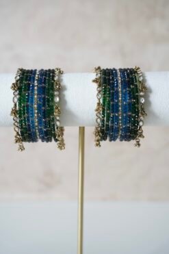 Deep blue and green Kashmiri glass bangle set inspired by peacock colors, featuring layered tones and a delicate ghungroo bangle at the edge of the stack