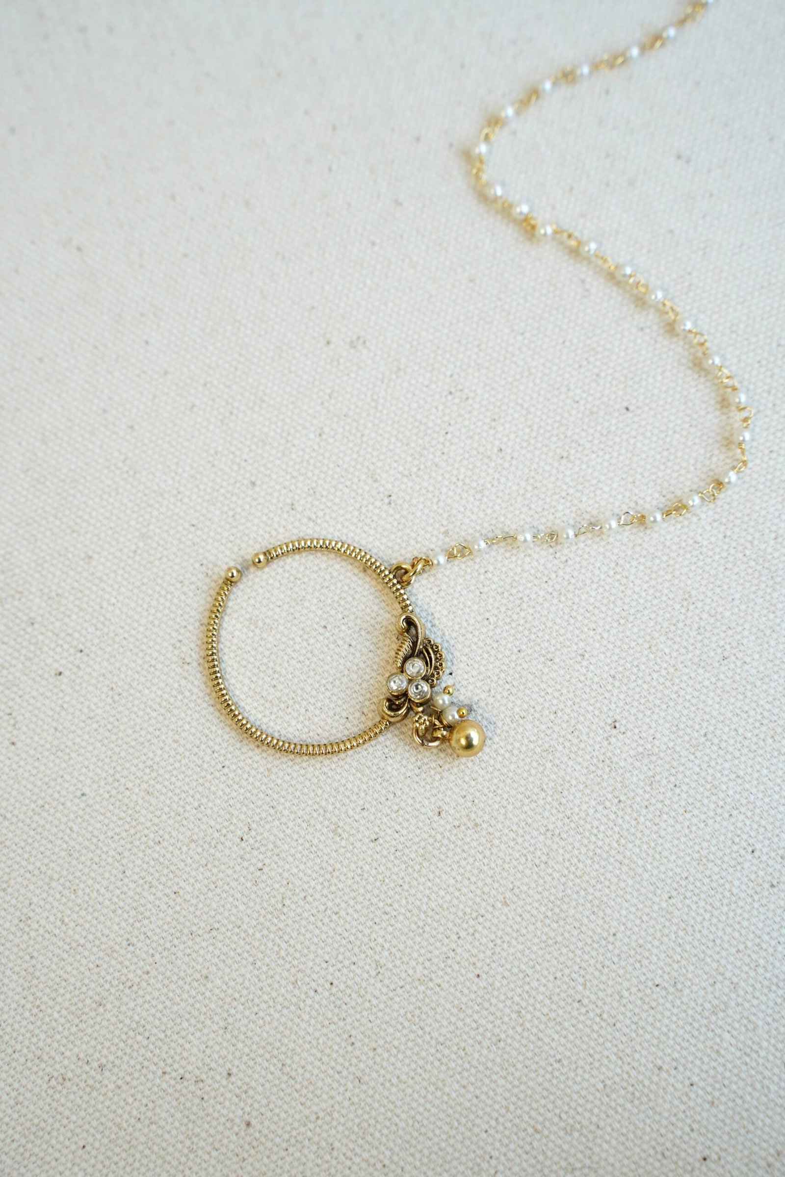Medium sized floral Kundan nath with a matte gold polish finish and a single layer chain by Seyora Jewels.