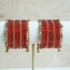 Red glass bangle stack with delicate ghungroo accent bangles for weddings, mehendi events, and festive wear.