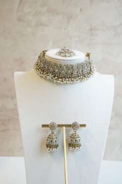 Three piece adjustable sparkling stone choker necklace set with matching earrings and a maang tikka with hanging pearl beads by Seyora Jewels.
