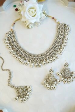 Sparkly flexible zircon necklace featuring flower shaped flower petal drop earrings and a matching pearl-beaded tikka.