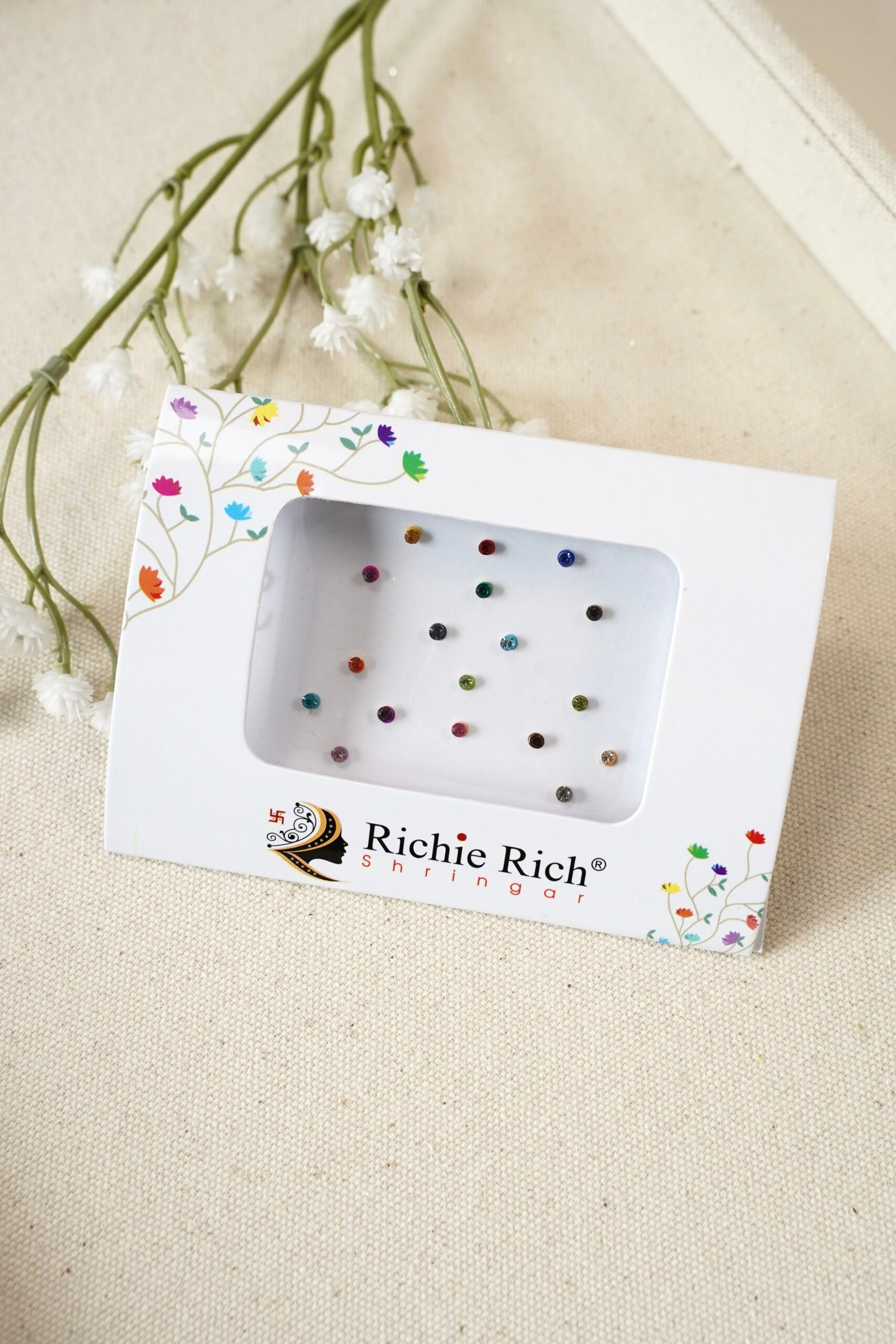 Pack of small multicolor bindis with central stone settings.