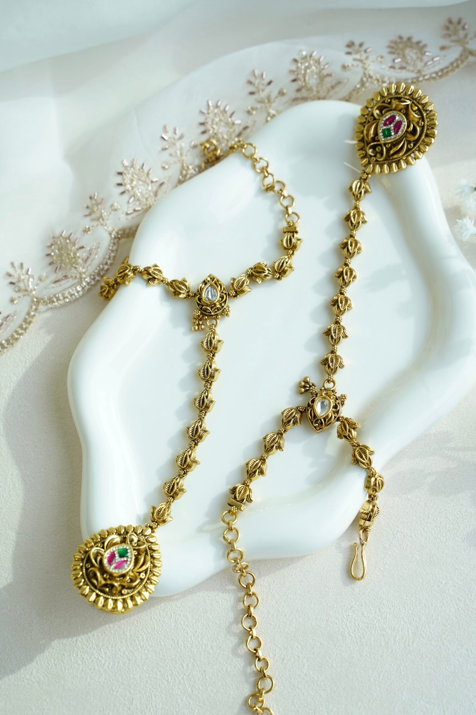 Seyora Jewels gold-plated Kundan hathpan hand chain featuring an oval rani pink and green finger ring connected to an adjustable wrist chain.