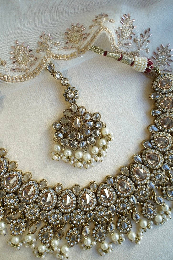Seyora Jewels Tanya necklace set featuring champagne stones and delicately hanging pearl beads with matching jhumka earrings and maang tikka.