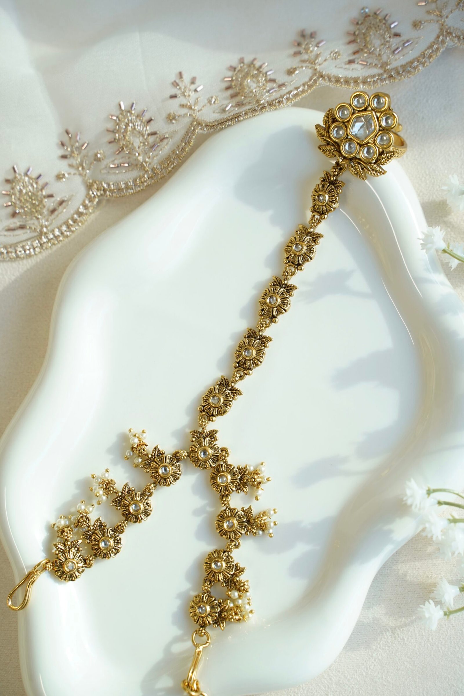 Seyora Jewels Diya floral Kundan hathpan hand chain featuring a kundan-studded flower ring and a detailed connecting chain linked to an adjustable wrist strap.