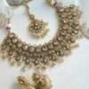 Seyora Jewels Tanya necklace set featuring champagne stones and hanging champagne crystal beads with matching jhumka earrings and maang tikka.