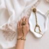 Seyora Jewels Kiran gold-plated Kundan hathpan hand chain featuring an oval rani pink and green finger ring connected to an adjustable wrist chain.