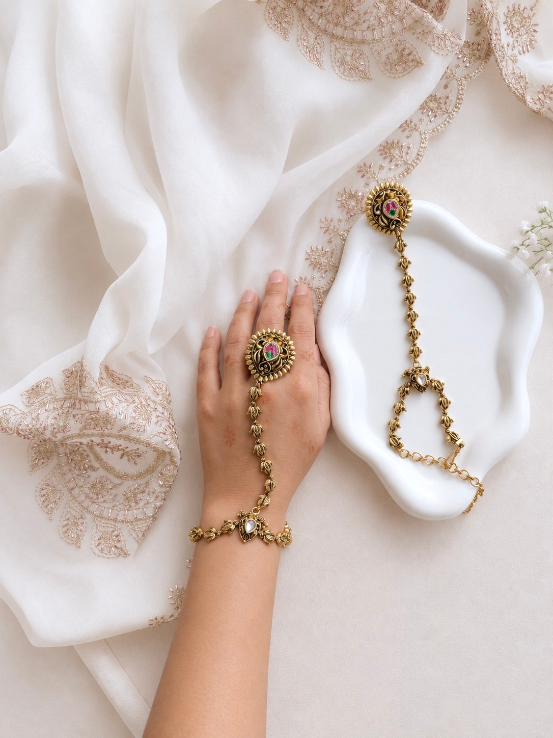 Seyora Jewels Kiran gold-plated Kundan hathpan hand chain featuring an oval rani pink and green finger ring connected to an adjustable wrist chain.