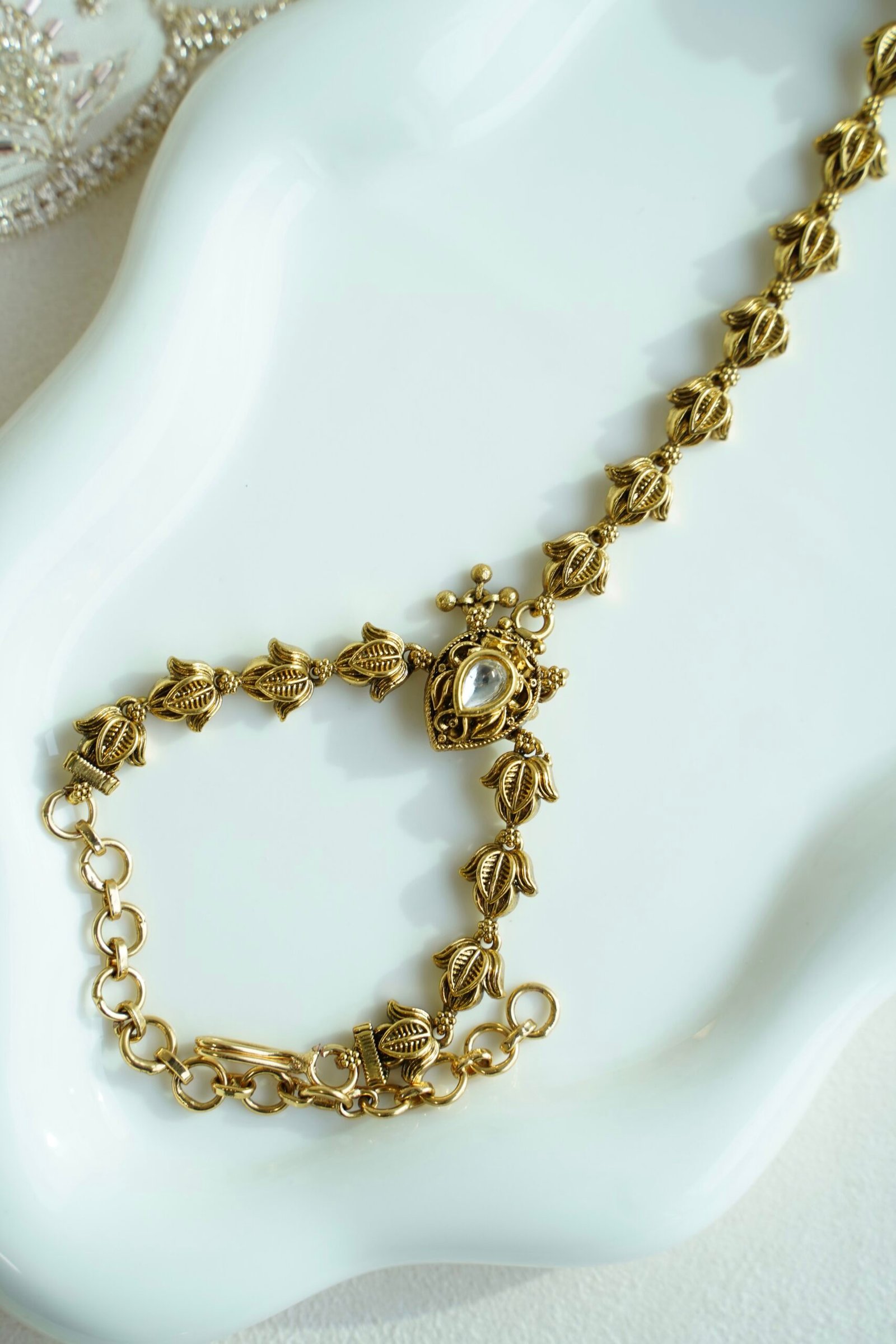 Seyora Jewels gold-plated Kundan hathpan hand chain featuring an oval rani pink and green finger ring connected to an adjustable wrist chain.