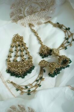 Seyora Jewels bridal jewelry set featuring a champagne stone necklace with emerald green beads, matching jhumka earrings with kanchain, maang tikka, and passa