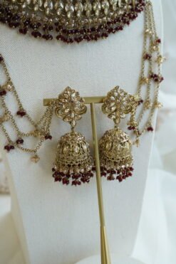 Seyora Jewels bridal jewelry set featuring a champagne stone necklace with maroon beads, matching jhumka earrings with kanchain, maang tikka, and passa.