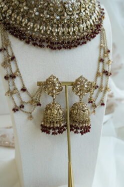 Seyora Jewels bridal jewelry set featuring a champagne stone necklace with maroon beads, matching jhumka earrings with kanchain, maang tikka, and passa.