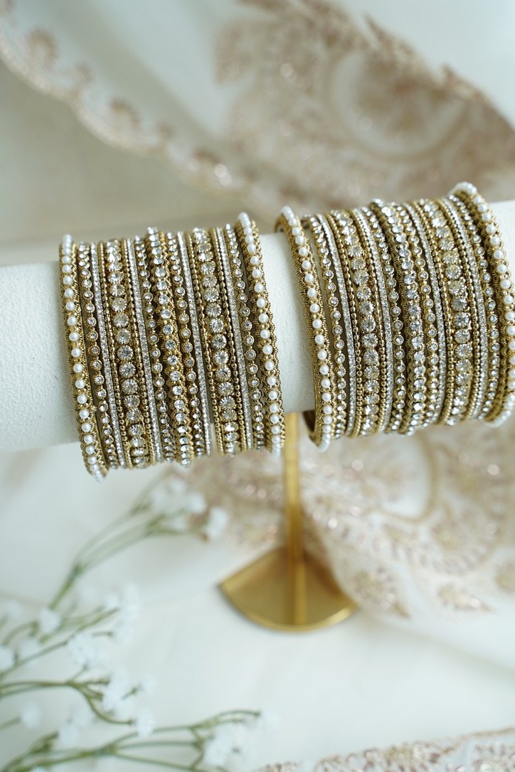 An elegant stack of South Asian bangles featuring a vibrant mix of different stone detailing and crystal embellishments by Seyora Jewels.