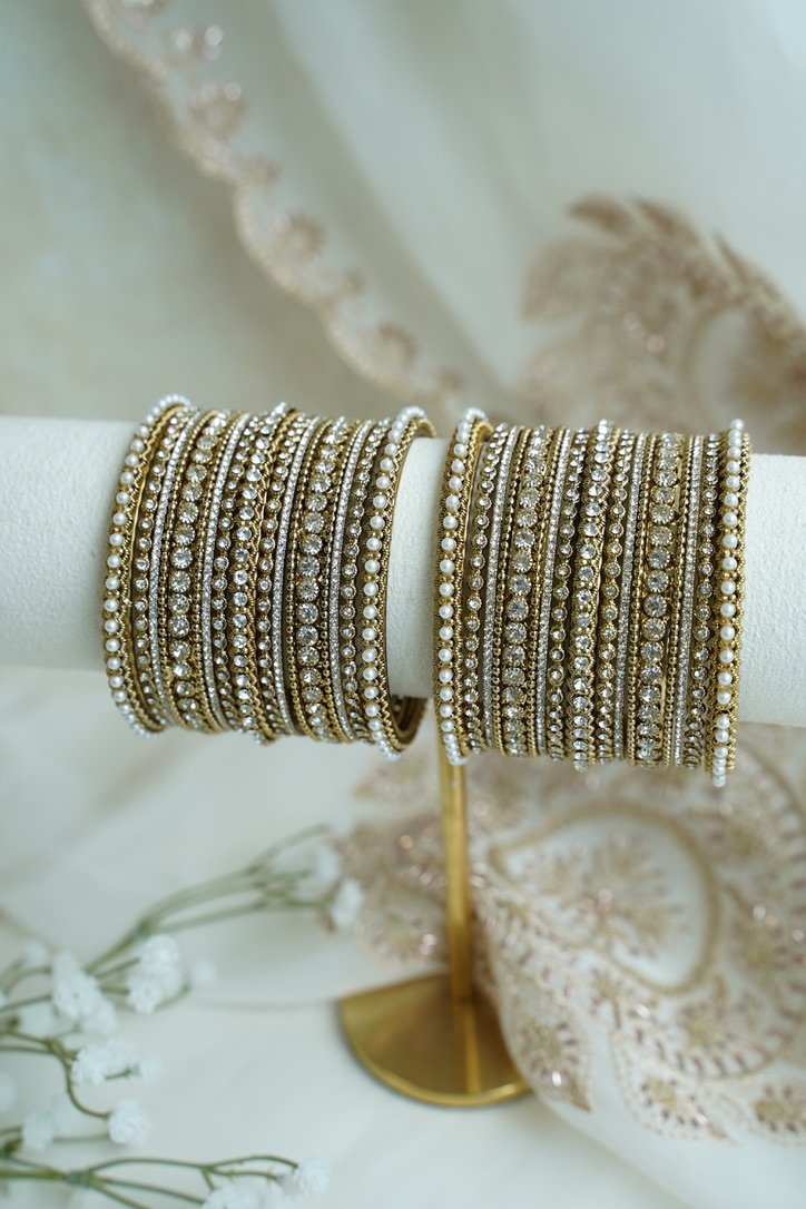 An elegant stack of South Asian bangles featuring a vibrant mix of different stone detailing and crystal embellishments by Seyora Jewels.
