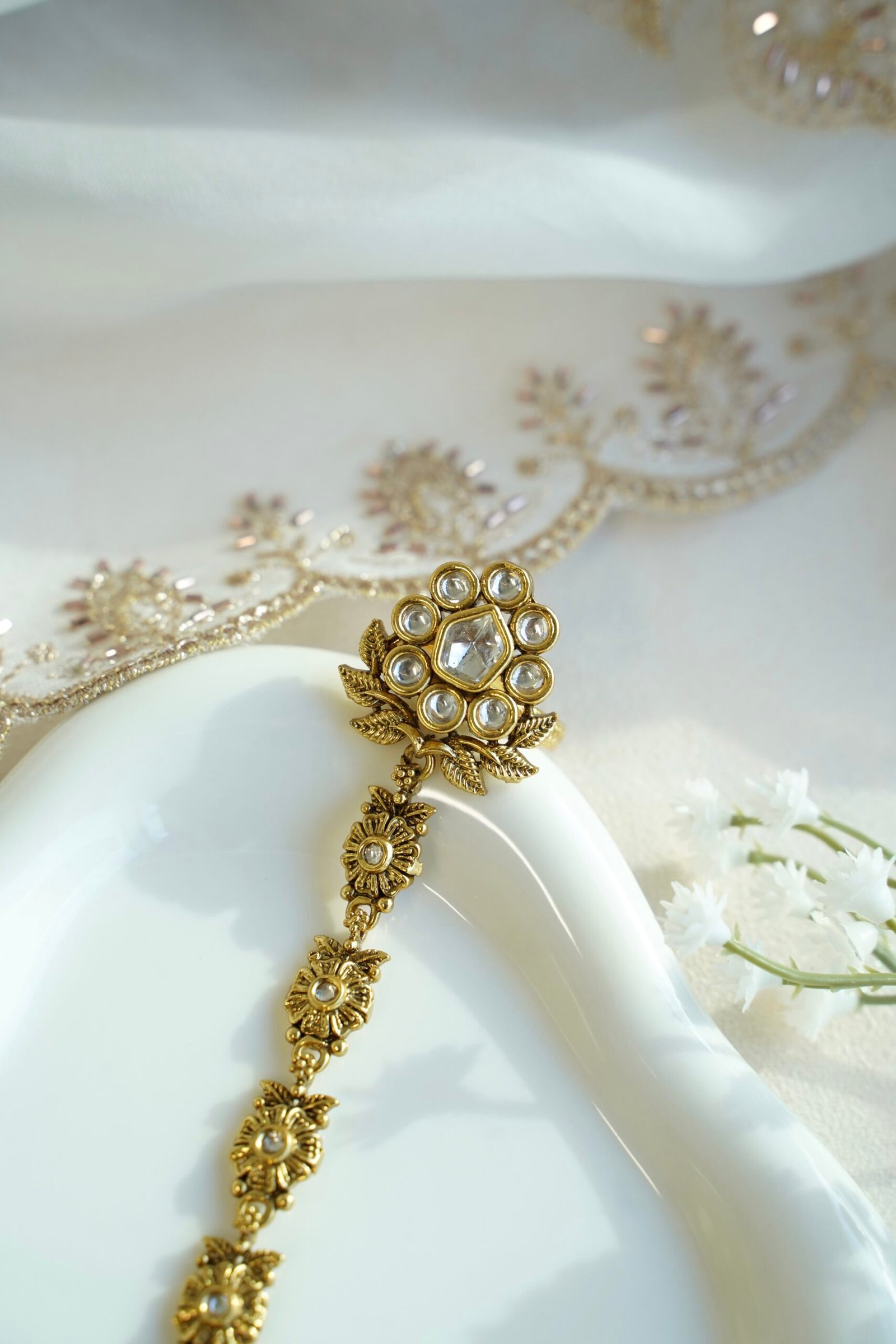 Seyora Jewels Diya floral Kundan hathpan hand chain featuring a kundan-studded flower ring and a detailed connecting chain linked to an adjustable wrist strap.