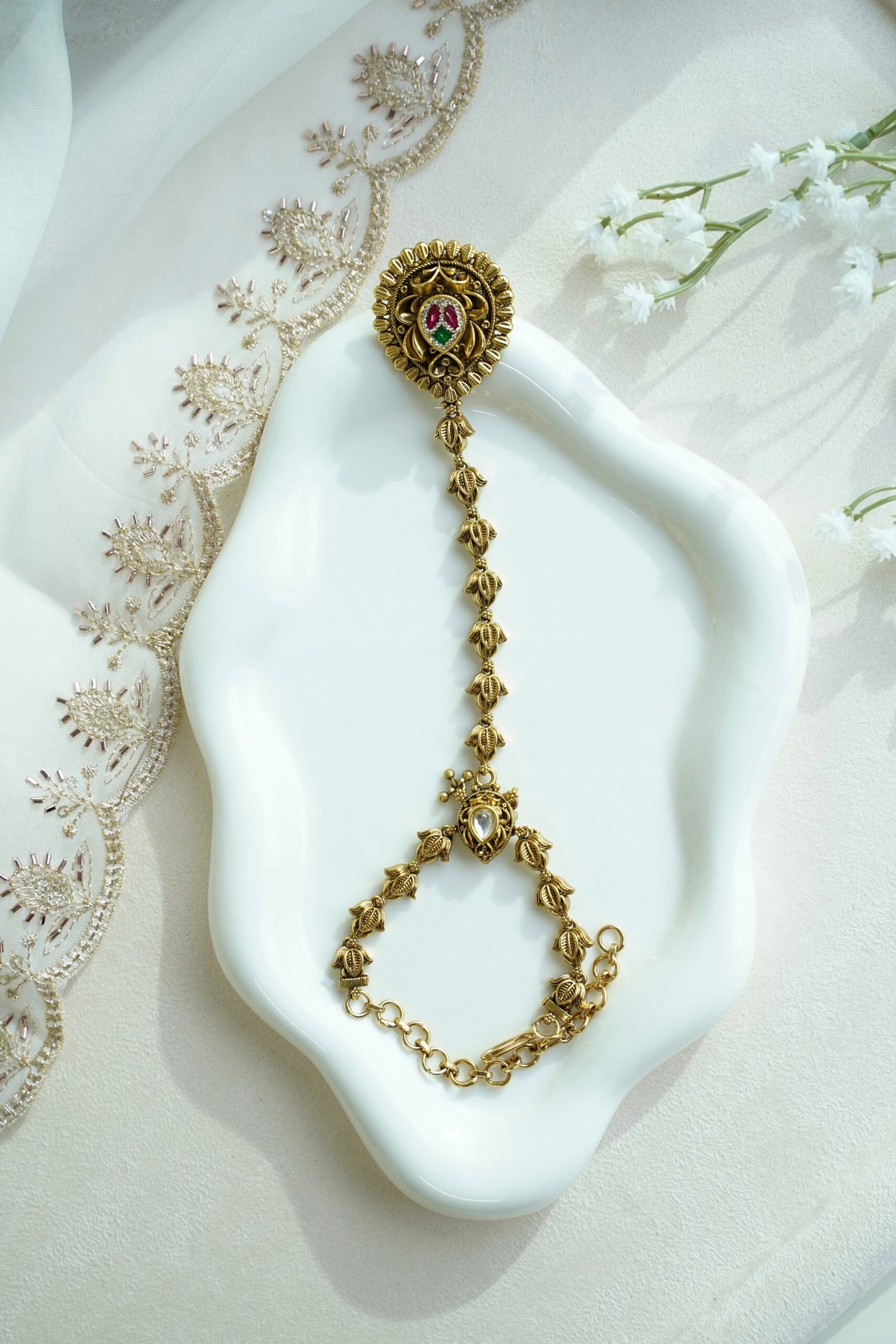 Seyora Jewels gold-plated Kundan hathpan hand chain featuring an oval rani pink and green finger ring connected to an adjustable wrist chain.